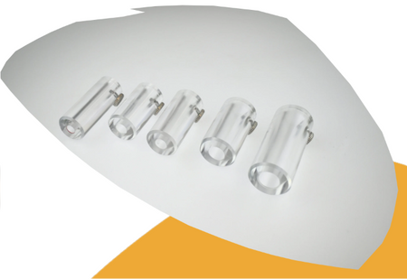 Five clear cylindrical plastic or glass clips arranged in a row on a white background with a yellow-orange shape underneath.
