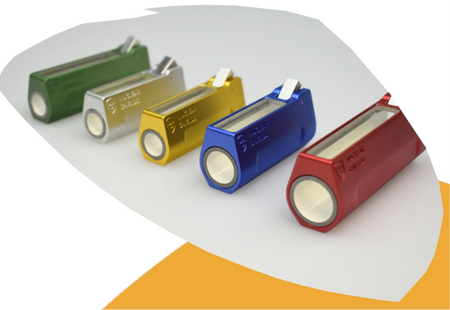 Five metallic cylindrical flashlight batteries in green, silver, gold, blue, and red, arranged diagonally on a white surface with a curved orange accent shape.